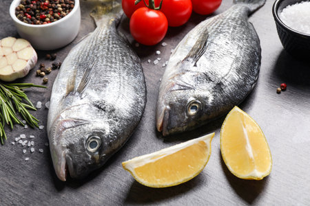 Raw dorada fish on gray table, closeup