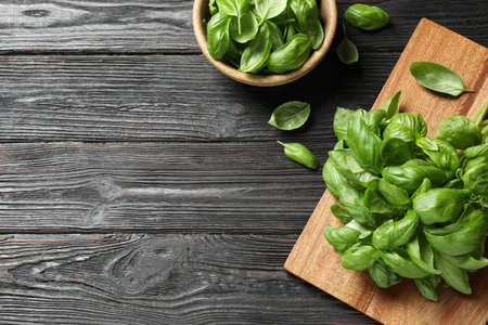 Fresh green basil on black wooden table, flat lay. Space for text