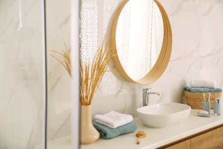 Round mirror over vessel sink in stylish bathroomの写真素材