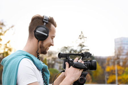 Video operator with professional camera working outdoors