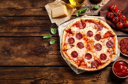 Flat lay composition with hot pepperoni pizza on wooden table. Space for textの写真素材