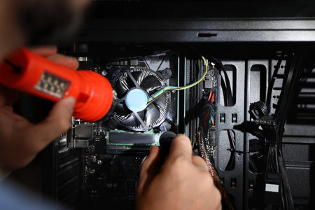 Man with flashlight fixing system unit indoors, closeup