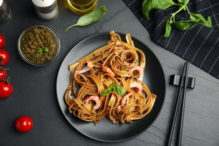 Tasty buckwheat noodles with shrimps served on black table, flat layの写真素材