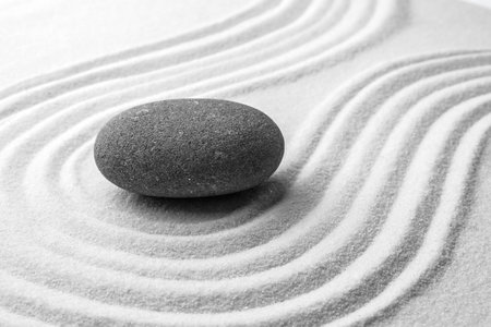Gray stone on sand with pattern. Zen, meditation, harmonyの写真素材