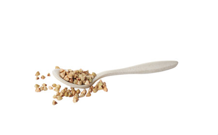 Spoon with organic green buckwheat isolated on whiteの写真素材
