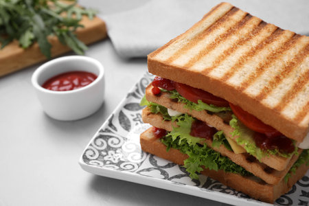 Yummy sandwich with tomato sauce served on gray table