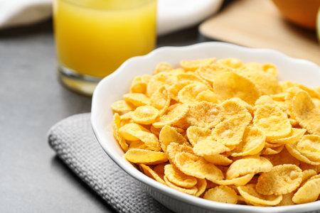 Tasty corn flakes on gray table, closeup