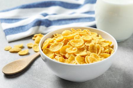 Tasty corn flakes on light gray table