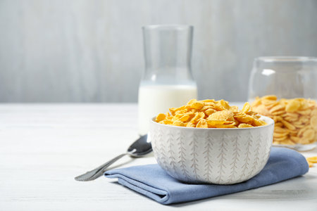 Tasty corn flakes on white wooden table