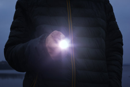 Man with flashlight walking outdoors, closeup viewの写真素材