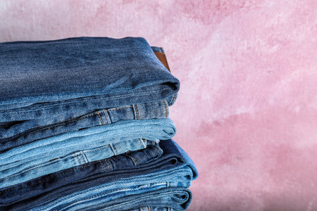 Stack of different jeans on pink background, closeupの写真素材