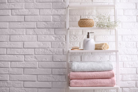 Clean towels on shelving unit in bathroom. Space for textの写真素材