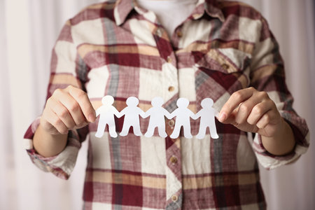 Woman holding paper people chain indoors, closeup. unity conceptの写真素材