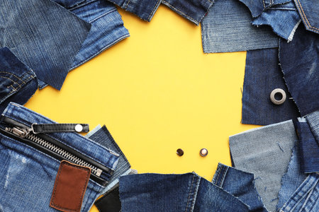 Frame made of cut jeans on yellow background. Space for textの写真素材