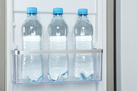 Bottles of water on shelf in fridgeの写真素材