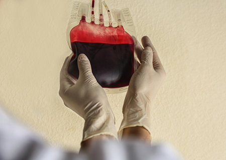 Woman holding blood for transfusion on beige background, closeup. Donation conceptの写真素材