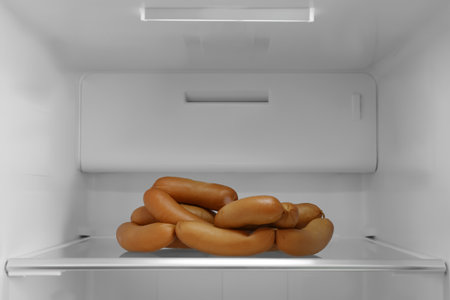 Tasty sausages on shelf of modern refrigeratorの写真素材