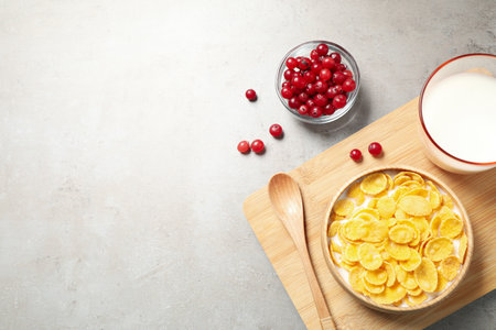 Flat lay composition with tasty corn flakes on light gray table. Space for text