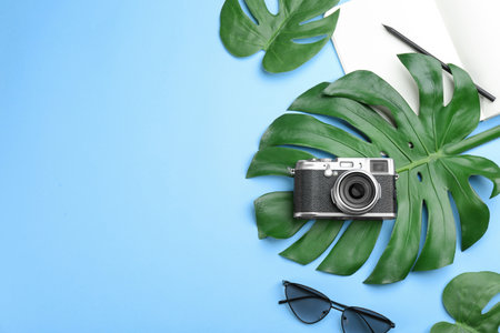 Flat lay composition with professional photographer camera on light blue background. Space for textの写真素材