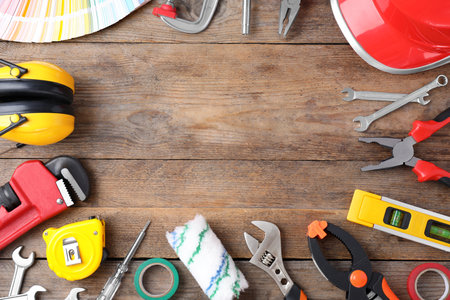 Flat lay composition with construction tools on wooden background. Space for text