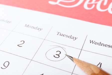 Pencil on calendar page with marked date, closeupの写真素材