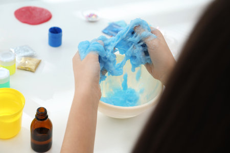 Little girl making DIY slime toy at table, closeupの写真素材