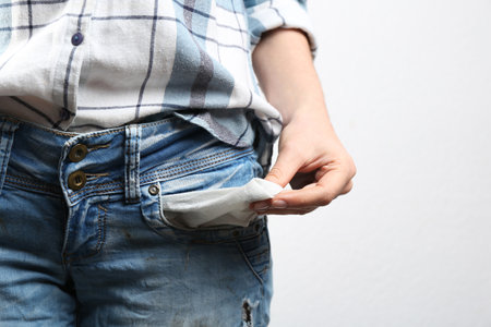 Woman showing empty pocket on light background, closeupの写真素材