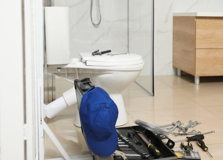 Plumber's tools near toilet bowl in bathroomの写真素材