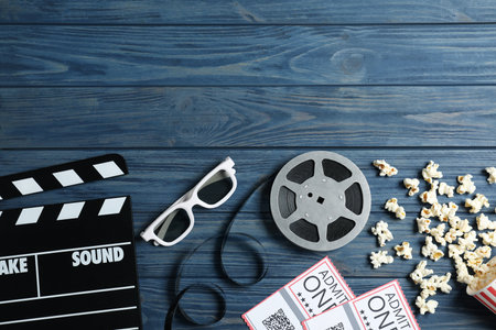 Flat lay composition with clapperboard and cinema tickets on blue wooden background, space for textの写真素材