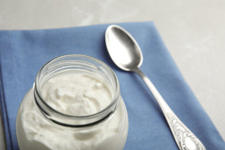 Tasty organic yogurt in glass jar, closeup. Space for textの写真素材