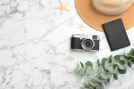 Flat lay composition with professional photographer camera, passport and space for text on white...