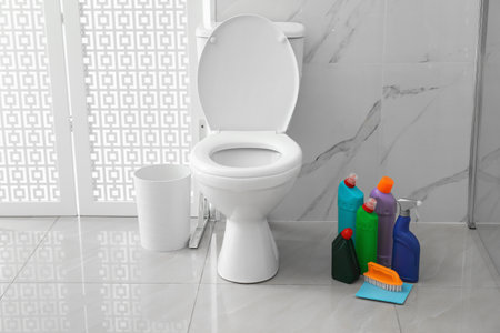 Toilet bowl and cleaning supplies in modern bathroomの写真素材