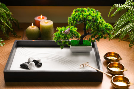 Beautiful miniature zen garden, candles and oil lamps on tableの写真素材