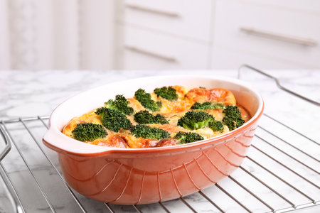 Tasty broccoli casserole in baking dish on cooling rackの写真素材