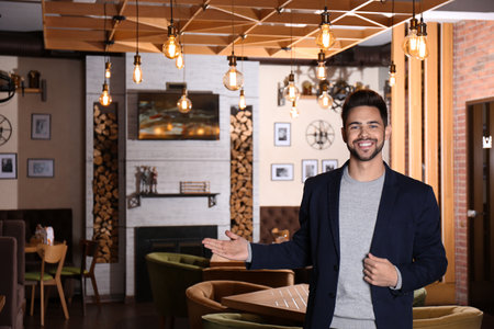 Young business owner standing in his cafe. Space for textの写真素材