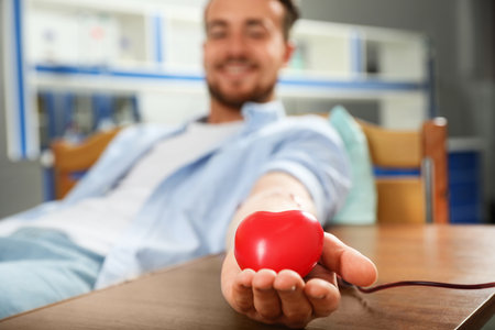 Young man making blood donation in hospital, focus on handの写真素材
