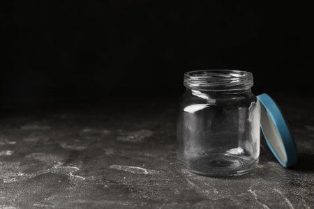 Empty glass jar on gray stone table, space for textの写真素材