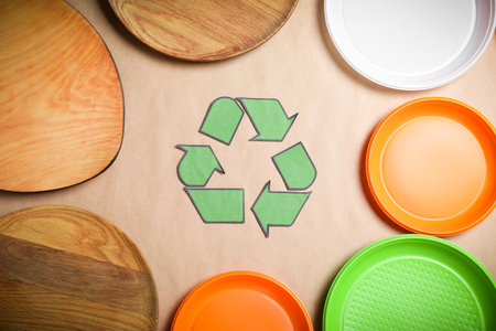 Recycling symbol, plastic and wooden plates on beige background, flat layの写真素材