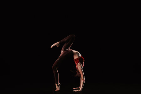 Young woman performing acrobatic element on stage indoorsの写真素材