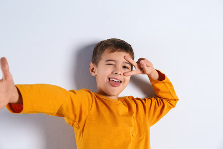 Portrait of cute little boy on light backgroundの写真素材