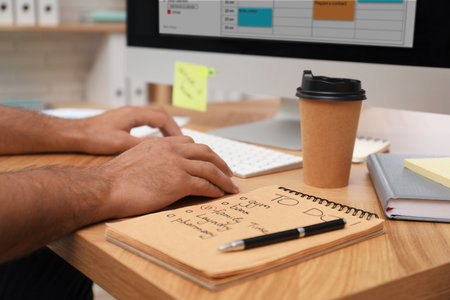 Man planning his schedule with calendar app on computer in office, closeup