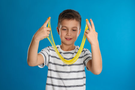 Little boy with slime on blue background