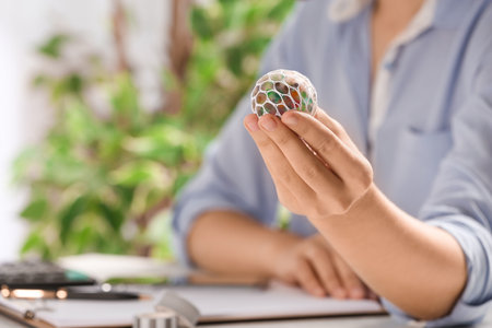 Woman with colorful slime in office, closeup. antistress toyの写真素材
