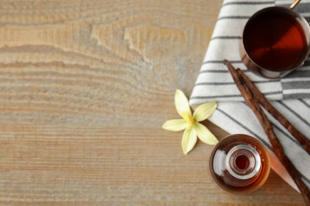 Flat lay composition with vanilla extract on wooden table. Space for textの写真素材