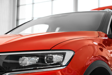 New luxury car in modern auto dealership, closeup