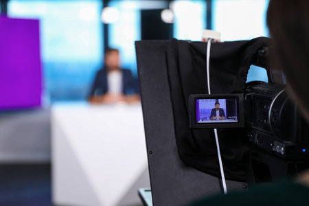 Presenter and video camera operator working in studio. News broadcastingの写真素材