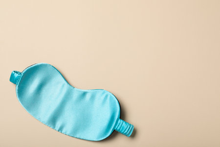 Turquoise sleeping mask on yellow background, top view with space for text. Bedtime accessoryの写真素材