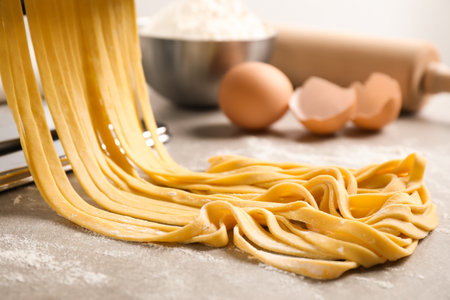Raw noodles with flour on gray table, closeup. Italian pastaの写真素材