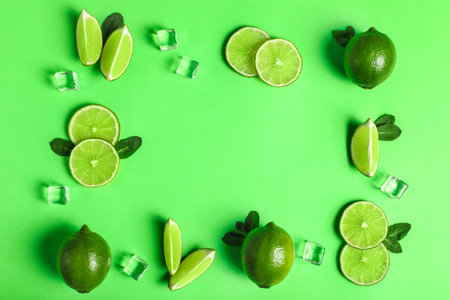 Flat lay composition with fresh juicy limes on light green background, space for textの写真素材