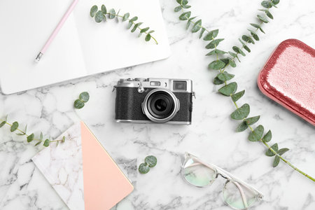 Flat lay composition with camera for professional photographer and accessories on white marble tableの写真素材
